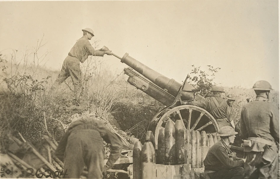 American soldiers operating a camouflaged 155-mm howitzer near Samogneux, France, in World War I.
